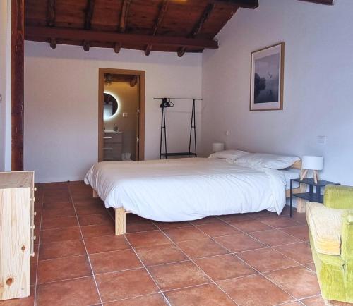 a bedroom with a bed and a tiled floor at Las raíces de los abuelos in Guadalix de la Sierra