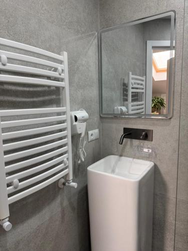 un bagno con un lavandino bianco e uno specchio di Bazar Motel a Chişinău