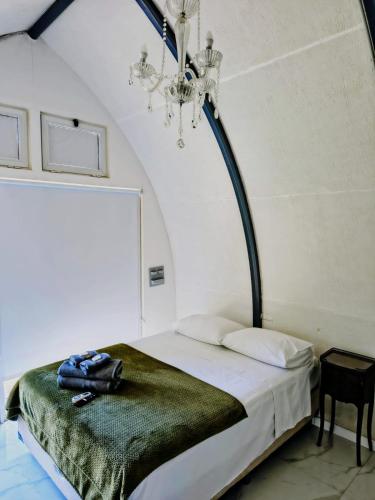 a bed in a room with a chandelier at Tiny house in Bahía Blanca