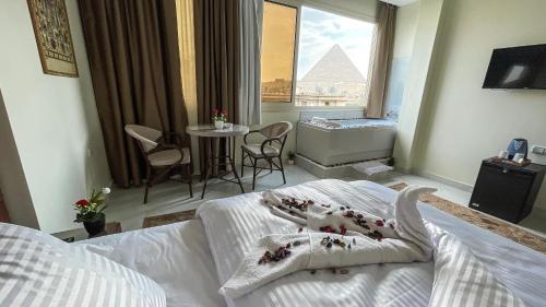 a bedroom with a bed and a view of the pyramids at Queen Inn Pyramids View in Cairo