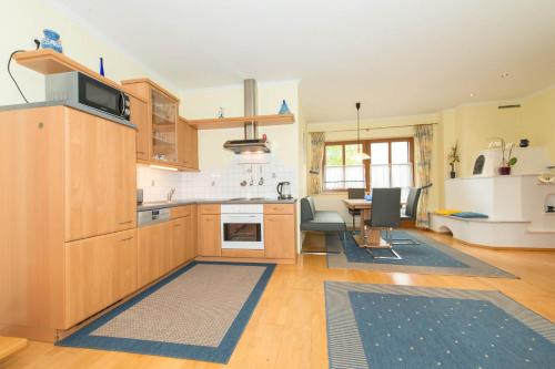 a kitchen with wooden cabinets and a dining room at Ferienwohnungen Kolbitsch in Greifenburg