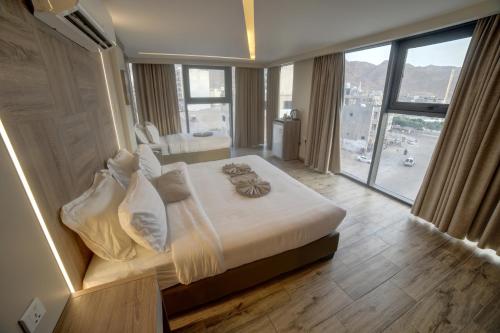 a bedroom with a large bed with a large window at Alena Boutique Hotel in Aqaba