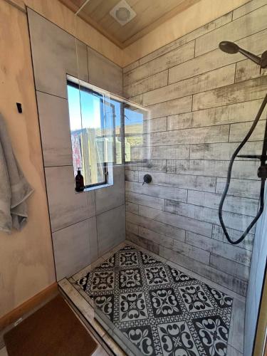 a bathroom with a shower with a tile floor at Mountain Range Guesthouse in Dovedale