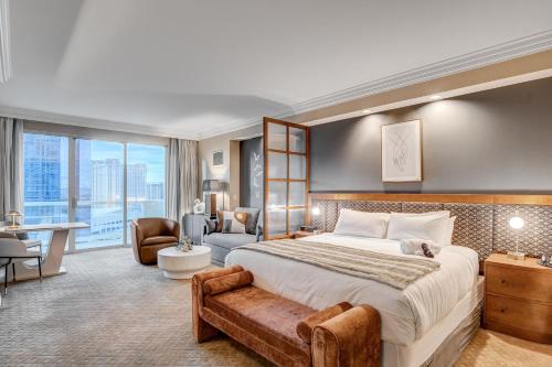 a hotel room with a large bed and a desk at MGM Signature Luxury Jr Suite with Balcony Strip and Sphere Views in Las Vegas
