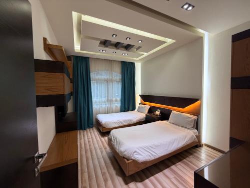a hotel room with two beds and a window at ZORA Suites hotel in Jounieh