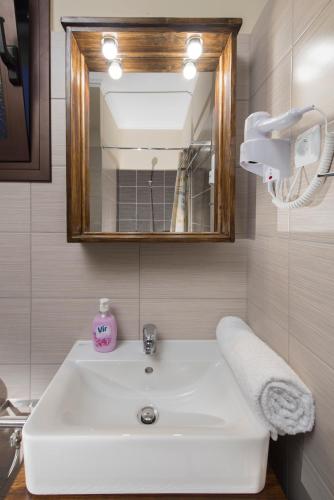 a bathroom with a white sink and a mirror at Margarita Rooms Sagiada in Sagiada