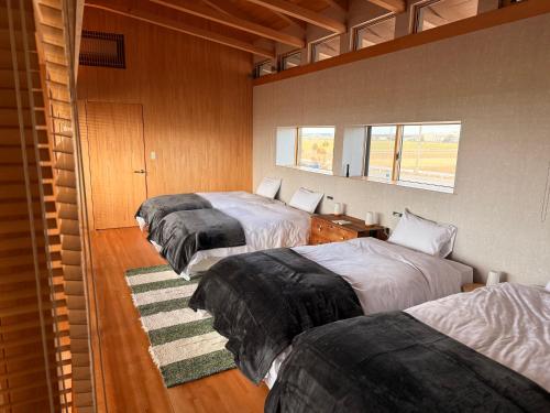 a bedroom with three beds and a window at the Mikuni Residence in Sakai