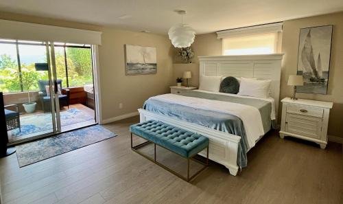 a bedroom with a large bed with a blue bench at Lake and the City Bed and Breakfast in West Kelowna