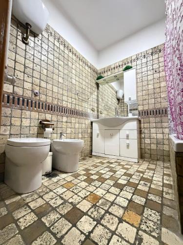 a bathroom with two toilets and a tiled wall at Victoria guesthouse in Rome