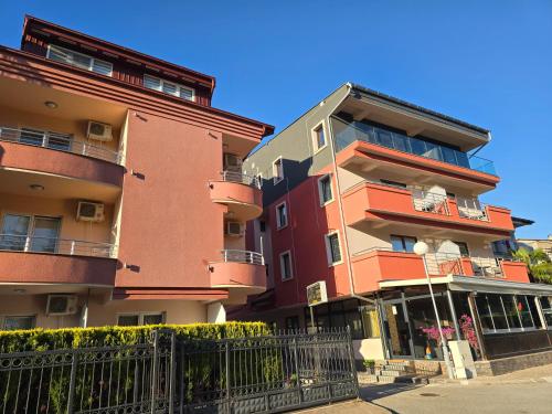 a tall building with a fence in front of it at Villa & Apartments Antigona in Ohrid