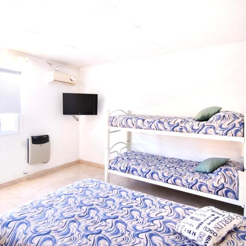 a room with two bunk beds and a flat screen tv at Gotas de Rocio N1 in San Antonio Oeste