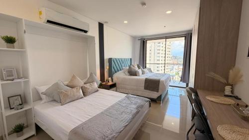 a bedroom with a bed and a desk and a table at Apartamento tipo Loft in Gaira