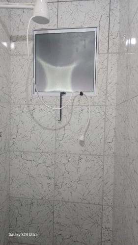 a bathroom with a shower with a screen on the wall at Cantinho dos netos-suites próximo ao Sesc em Bertioga in Bertioga