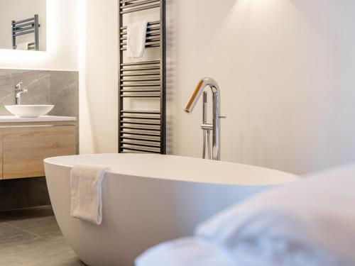 a bathroom with a white tub and a sink at Grebenzen Lodge 44 in Sankt Lambrecht