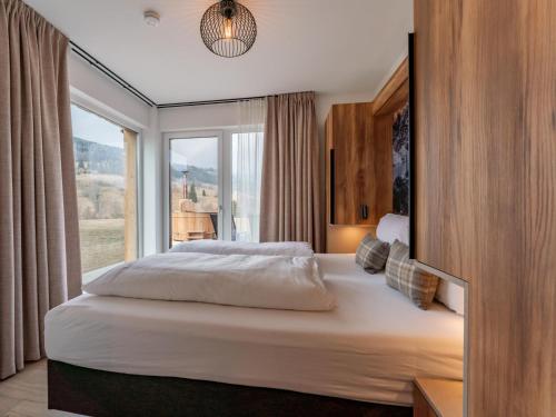 a bedroom with a large bed with a large window at Grebenzen Lodge 44 in Sankt Lambrecht