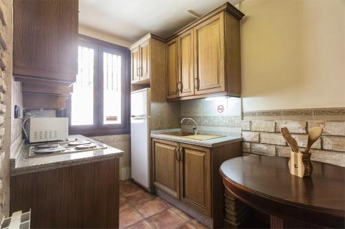 a kitchen with wooden cabinets and a counter top at Arte Vida Suites & Spa in Granada