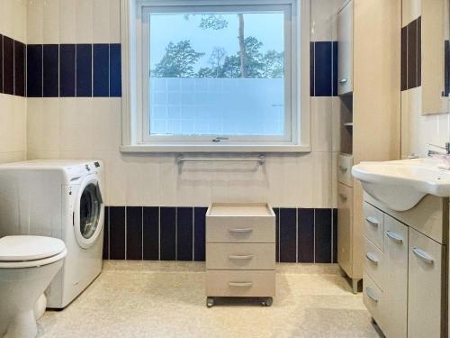a bathroom with a washing machine and a window at 8 person holiday home in Mönsterås in Mönsterås