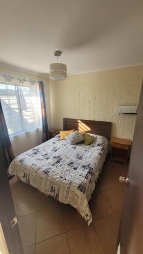 a bedroom with a bed and a window at Acogedora Casa en Talca sector bicentenario 3 dormitorios 7 personas in Talca