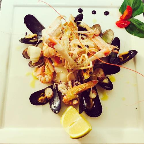 a plate of food with shrimp and mussels at Hotel Garden Bocca di Magra in Bocca di Magra