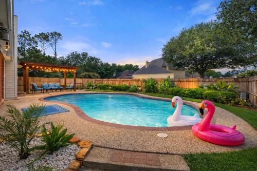 two inflatable swans in a pool in a yard at Amazing Bay Villa Near NASA with Pool & Pool Table in Houston