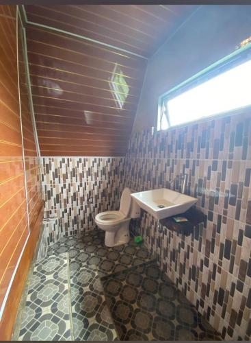 a bathroom with a toilet and a sink at VILA RINJANI PARADAIS IIn in Sajang