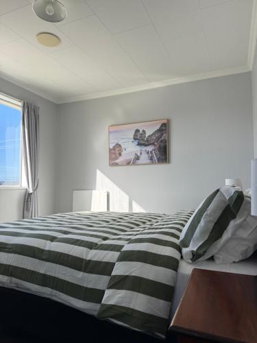 a bedroom with a black and white striped bed at Delight On Dalton in Hokitika