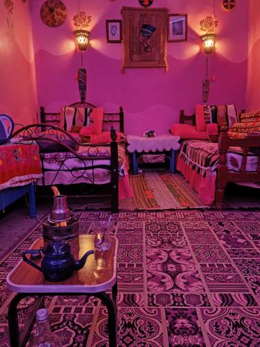 a room with two beds and a cat sitting on a table at Miral Nubian House in Aswan