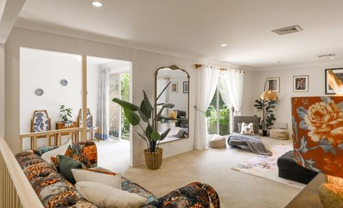 a living room with a couch and a mirror at Linden Getaway Bowral in Bowral