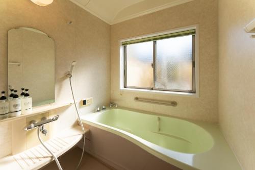 a bathroom with a large tub and a window at 野町 庵 in Kanazawa