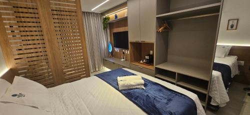 a hotel room with two beds and a mirror at Beach Class Verano Muro Alto in Porto De Galinhas