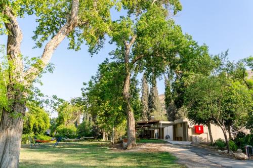 a house with trees in front of a yard at Bait Alfa Kibbutz Country Lodging in Bet Alfa