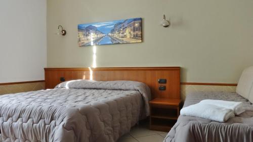 a bedroom with two beds and a picture on the wall at Hotel Astrid in Milan