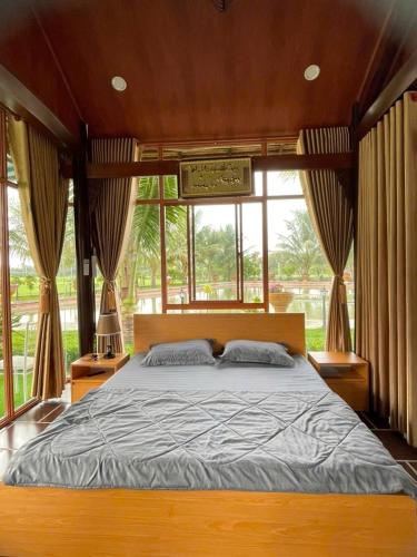 a bedroom with a large bed in front of a window at Melalueca tay ninh in Tây Ninh