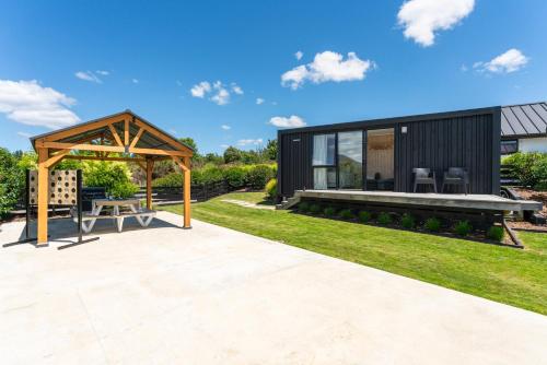 a contemporary garden with a black house with a pavilion at Thomson's Nook - Taupo in Taupo
