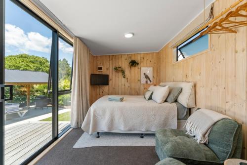 a bedroom with a bed and a sliding glass door at Thomson's Nook - Taupo in Taupo