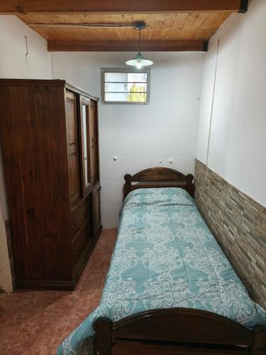 a small bedroom with a bed and a window at Cabañas Tierra del molino in General Alvear