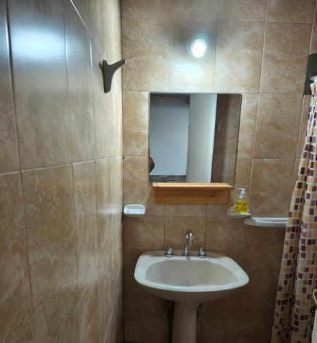 a bathroom with a sink and a mirror at Cabañas Tierra del molino in General Alvear