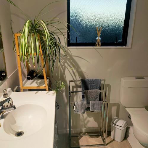 a bathroom with a sink and a potted plant at One8Endeavour in Tauranga