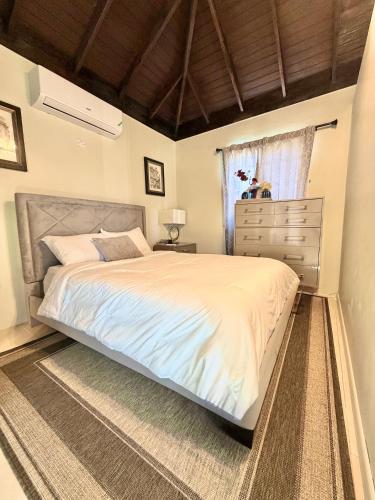 ein Schlafzimmer mit einem Bett, einer Kommode und einem Fenster in der Unterkunft Urban Loft in Falmouth