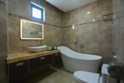 a bathroom with a large tub and a sink at An Gia Hotel in Quy Nhon