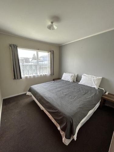 a bedroom with a large bed and a window at Town Centre Retreat in Taupo