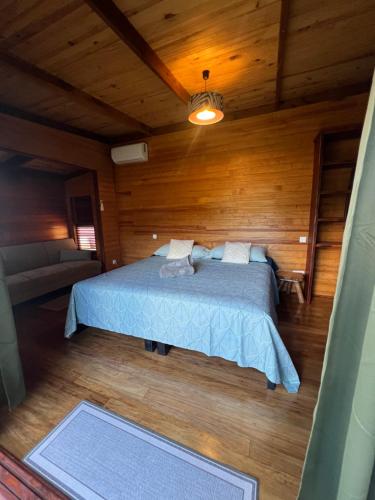 a bedroom with a bed in a wooden room at Manuia House in Bora Bora