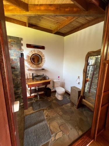 a bathroom with a toilet and a wooden table at Manuia House in Bora Bora