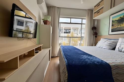 a bedroom with a bed and a large window at Asa Sul | Próx. Aeroporto | Conforto & Praticidade in Brasília