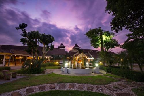 a night view of a house with lights in the yard at Luckswan Resort Chiang Rai - SHA Extra Plus in Chiang Rai