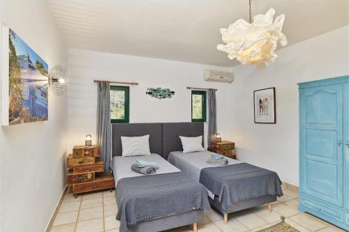 a bedroom with two beds and a chandelier at Casa Brisa Do Rio, Malhada do São - Rural in Tavira