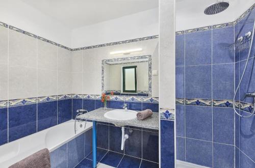 a blue tiled bathroom with a sink and a shower at Casa Brisa Do Rio, Malhada do São - Rural in Tavira