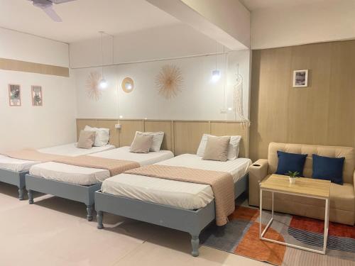 a room with three beds and a couch at A Day Rayong in Ban Pa Khan