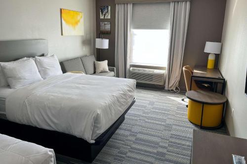 a hotel room with a bed and a chair and a desk at Comfort Inn & Suites in Lubbock