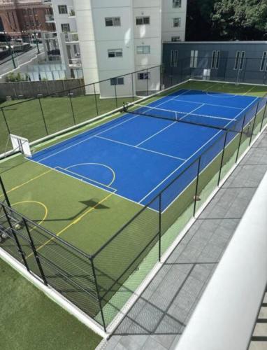 a tennis court with two tennis courts at 2 FREE PARKING Penthouse with Harbour & Arena Views in Auckland
